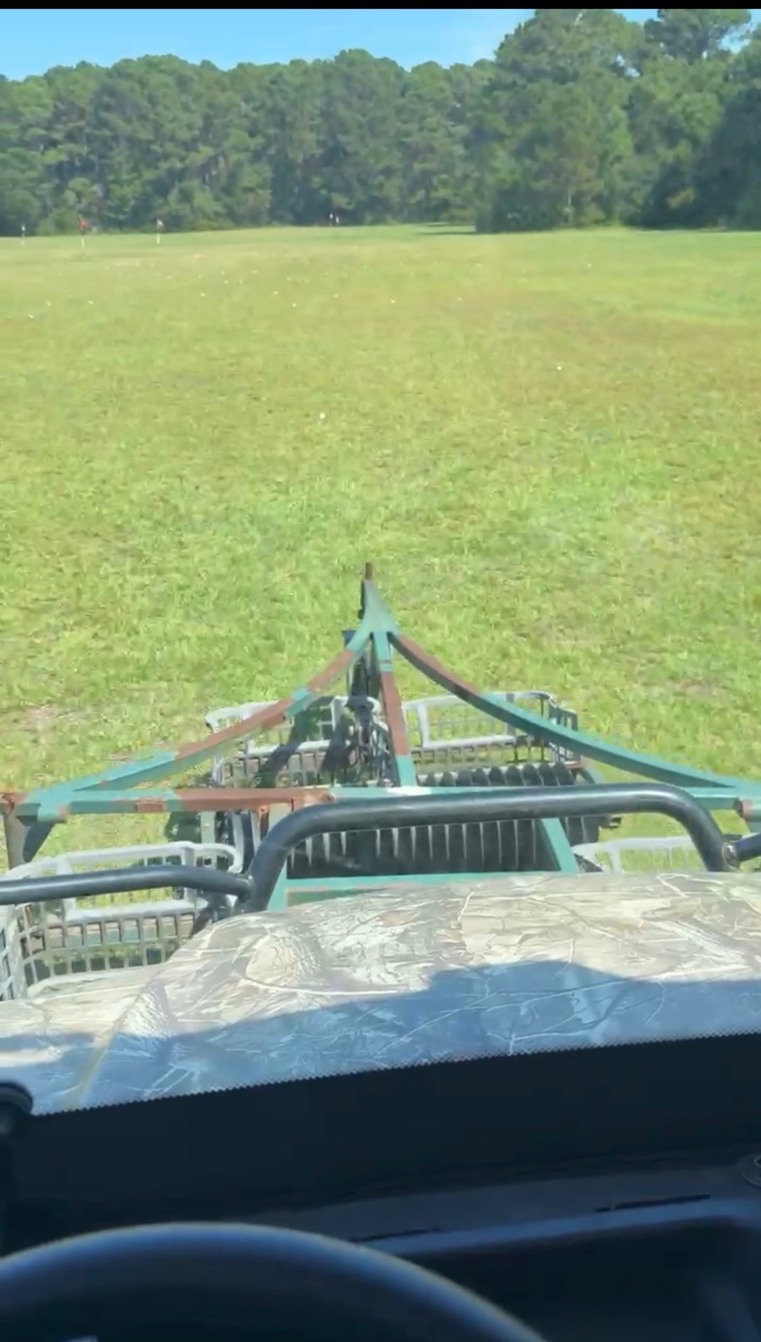 Ball picker rolling across the green driving range field
